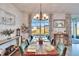Sunlit dining room with wooden table, decorative chandelier, and views of the outdoors at 12940 Brookside Moss Dr, Riverview, FL 33579