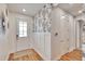 Bright entryway with wood-look floors, decorative wallpaper, and board and batten accent wall at 12940 Brookside Moss Dr, Riverview, FL 33579