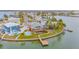 Breathtaking aerial view of a waterfront home with a private dock, lush greenery, and a refreshing swimming pool at 16134 4Th E St, Redington Beach, FL 33708