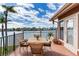 Relaxing balcony with patio furniture, offering a view of the water and nearby homes at 16134 4Th E St, Redington Beach, FL 33708