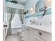 Bathroom with a white vanity, oval mirror, and a blue accent tile at 16134 4Th E St, Redington Beach, FL 33708