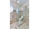 Shower with glass door featuring a built-in toilet, window, tile surround and flooring at 16134 4Th E St, Redington Beach, FL 33708