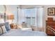 Bedroom featuring bed with accent pillows, a reading chair, and window with sheer curtains, providing a bright atmosphere at 16134 4Th E St, Redington Beach, FL 33708