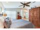 Comfortable bedroom features an armoire, ceiling fan, and bed with accent pillows, offering a cozy space at 16134 4Th E St, Redington Beach, FL 33708