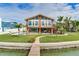 Charming waterfront home featuring a balcony, outdoor seating, pool, and lush landscaping at 16134 4Th E St, Redington Beach, FL 33708