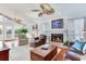 Cozy living room featuring a fireplace, vaulted ceilings, and access to outdoor deck at 16134 4Th E St, Redington Beach, FL 33708
