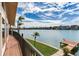Scenic waterfront view from balcony with dock, turquoise water and palm trees at 16134 4Th E St, Redington Beach, FL 33708