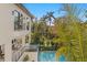 Stunning backyard view featuring a pool, lush landscaping, and multi-level balconies of the modern home at 337 Coffee Pot Ne Dr, St Petersburg, FL 33704