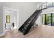 Interior view featuring open staircase, light hardwood floors, and view to outdoor foliage at 337 Coffee Pot Ne Dr, St Petersburg, FL 33704