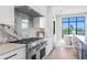 Gourmet kitchen features a professional range and hood, custom marble backsplash, and views to the outdoor living area at 337 Coffee Pot Ne Dr, St Petersburg, FL 33704