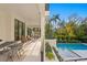 Outdoor living and dining space next to a pool, enhanced by verdant landscaping, create an inviting atmosphere at 337 Coffee Pot Ne Dr, St Petersburg, FL 33704