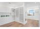 Spacious walk-in closet boasts custom shelving, drawers, and ample storage space on hardwood floors at 337 Coffee Pot Ne Dr, St Petersburg, FL 33704