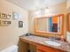Bathroom with framed mirror, granite countertop and storage, and decorative shell art on the wall at 343 Rex Pl # F, Madeira Beach, FL 33708