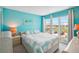 Bedroom with blue walls, light carpet, a ceiling fan and a large window with views of the city at 343 Rex Pl # F, Madeira Beach, FL 33708