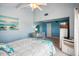 Main bedroom featuring a ceiling fan, a large mirror, blue walls, and light colored carpets at 343 Rex Pl # F, Madeira Beach, FL 33708