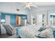 Spacious main bedroom with blue walls, a ceiling fan, light-colored carpet, and large windows at 343 Rex Pl # F, Madeira Beach, FL 33708