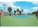 Well-maintained community tennis court with green and blue surface, surrounded by palm trees and fencing at 343 Rex Pl # F, Madeira Beach, FL 33708