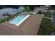 Aerial view of the community pool with a lake and tennis courts, all within walking distance at 34421 Countryside Dr, Wesley Chapel, FL 33543
