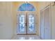 Inviting foyer with decorative double doors, transom window, and tile flooring at 4553 31St E Ct, Bradenton, FL 34203