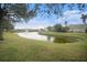 Scenic community pond featuring a fountain, green space, and mature trees at 534 19Th Nw St, Ruskin, FL 33570