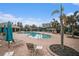 Community swimming pool surrounded by lounge chairs and tables with umbrellas at 534 19Th Nw St, Ruskin, FL 33570