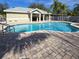 Inviting community pool with clear blue water surrounded by a brick patio at 558 Harbor Ridge Dr, Palm Harbor, FL 34683