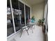 Cozy patio with small glass-top table, two chairs, and potted plants at 558 Harbor Ridge Dr, Palm Harbor, FL 34683