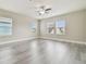 Bright bedroom features wood-look floors, a ceiling fan, and multiple windows at 7714 S West Shore Blvd, Tampa, FL 33616