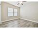 Neutral bedroom with ceiling fan, two windows, and wood-look floors at 7714 S West Shore Blvd, Tampa, FL 33616
