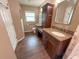 Bathroom with dual vanity, granite countertop, wood cabinets, tile flooring, and a walk-in shower at 1604 Boswell Ln, New Port Richey, FL 34655