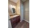 Bathroom with wood floor, granite countertop, brown cabinets, and tan walls at 1604 Boswell Ln, New Port Richey, FL 34655