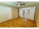 Bedroom with wood-look floors, double-door closets, and a ceiling fan with a view into the other room at 1604 Boswell Ln, New Port Richey, FL 34655