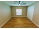 Bedroom featuring a ceiling fan, light-colored wood floors, neutral paint, and a double-door closet at 1604 Boswell Ln, New Port Richey, FL 34655