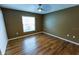 Bedroom featuring wood floors, a ceiling fan, and a bright window in a house at 1604 Boswell Ln, New Port Richey, FL 34655