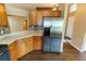 Spacious kitchen with wood cabinets, stainless steel refrigerator, and granite countertops at 1604 Boswell Ln, New Port Richey, FL 34655