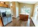 Bright eat-in kitchen with stainless steel refrigerator, central kitchen island, and modern wood flooring at 1604 Boswell Ln, New Port Richey, FL 34655