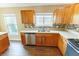 Well-lit kitchen featuring wood cabinets, stainless steel appliances, and a decorative backsplash at 1604 Boswell Ln, New Port Richey, FL 34655