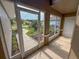 Cozy screened-in porch with tiled flooring and wrought iron door overlooking the lush front yard at 1604 Boswell Ln, New Port Richey, FL 34655