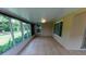Spacious sunroom with tile flooring and views of the landscaped backyard through large windows at 1604 Boswell Ln, New Port Richey, FL 34655