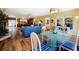 Open-concept dining area with a modern glass table and views of the backyard at 16301 Redington Dr, Redington Beach, FL 33708