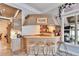 Cozy bar area with wood paneling, bar seating, and a view to the kitchen and exterior at 214 Bon Vie Pl, Valrico, FL 33594