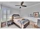 Cozy bedroom with white wainscoting, shuttered window, and ceiling fan at 214 Bon Vie Pl, Valrico, FL 33594