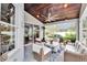 Screened-in patio featuring a ceiling fan, wood ceiling, and cozy wicker furniture at 214 Bon Vie Pl, Valrico, FL 33594