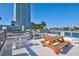 Community deck with picnic tables and seating overlooks serene waterfront views on a beautiful day at 31 Island Way # 303, Clearwater Beach, FL 33767