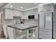 Modern white kitchen with stainless steel appliances and an island with seating at 31 Island Way # 303, Clearwater Beach, FL 33767