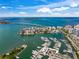 Stunning aerial view showcasing a vibrant coastal city, marina, and expansive ocean with a bridge in the distance at 3987 Maceachen Blvd # 133, Sarasota, FL 34233