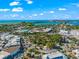 Captivating aerial view of a charming coastal town with a roundabout, lush trees, and the ocean in the distance at 3987 Maceachen Blvd # 133, Sarasota, FL 34233