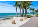 Picturesque beachside pathway lined with palm trees and decorative spheres overlooking the beautiful ocean at 3987 Maceachen Blvd # 133, Sarasota, FL 34233