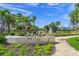 Scenic view of 'The Bay' sign with lush greenery, water, and palm trees at 3987 Maceachen Blvd # 133, Sarasota, FL 34233