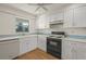 Bright kitchen featuring white cabinets, modern appliances, and hardwood floors at 3987 Maceachen Blvd # 133, Sarasota, FL 34233